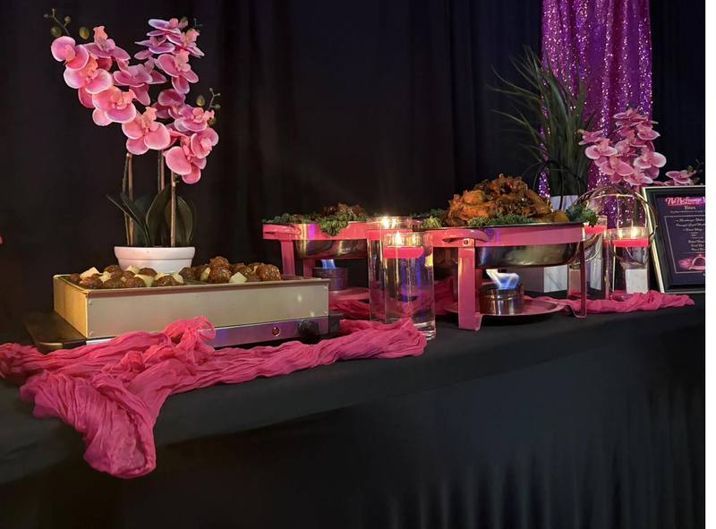 Flavor and Flair Catering Elevated Dining buffet with chafing dishes, hot wings, and pink floral decor